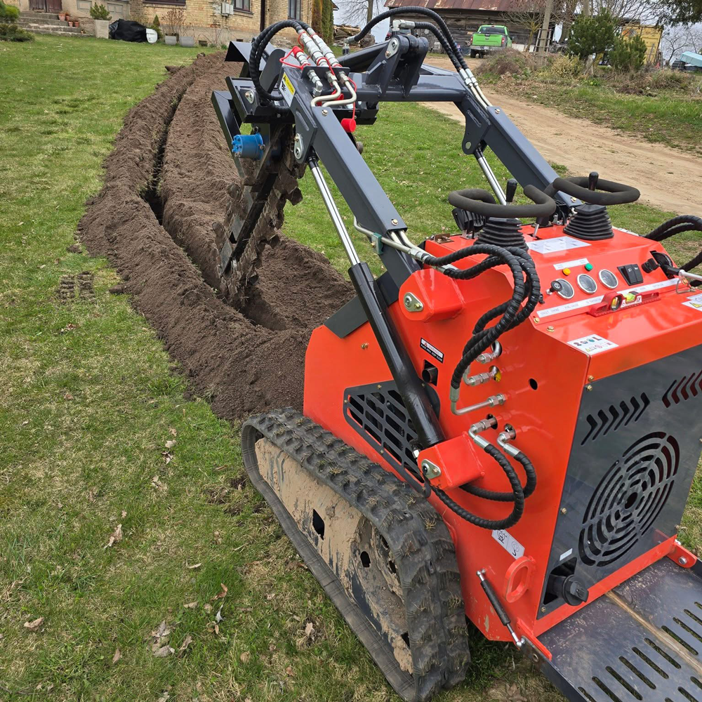 Ein Minilader mit Grabenfräse zieht einen langen Graben für Kabel und Leitungen.